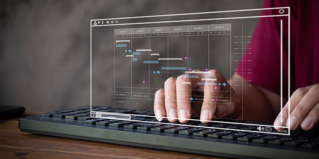 Two hands typing on a keyboard and showing a planning